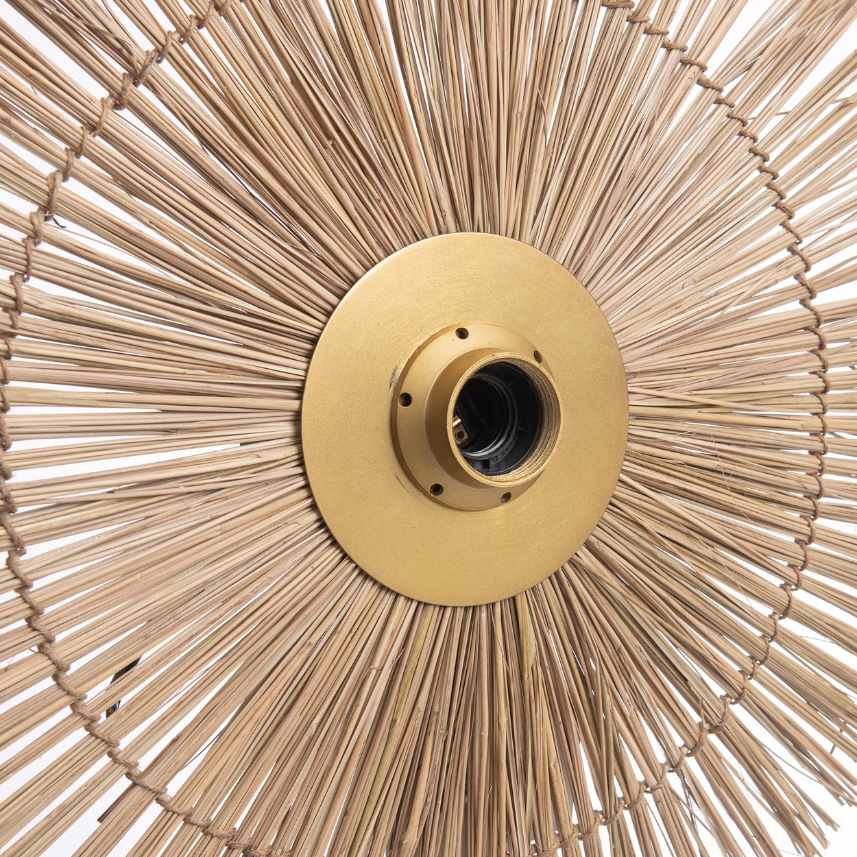 The Beausoleil Wall Lamp in natural gold, featuring a medium-sized handwoven grass shade with subtle brass detailing