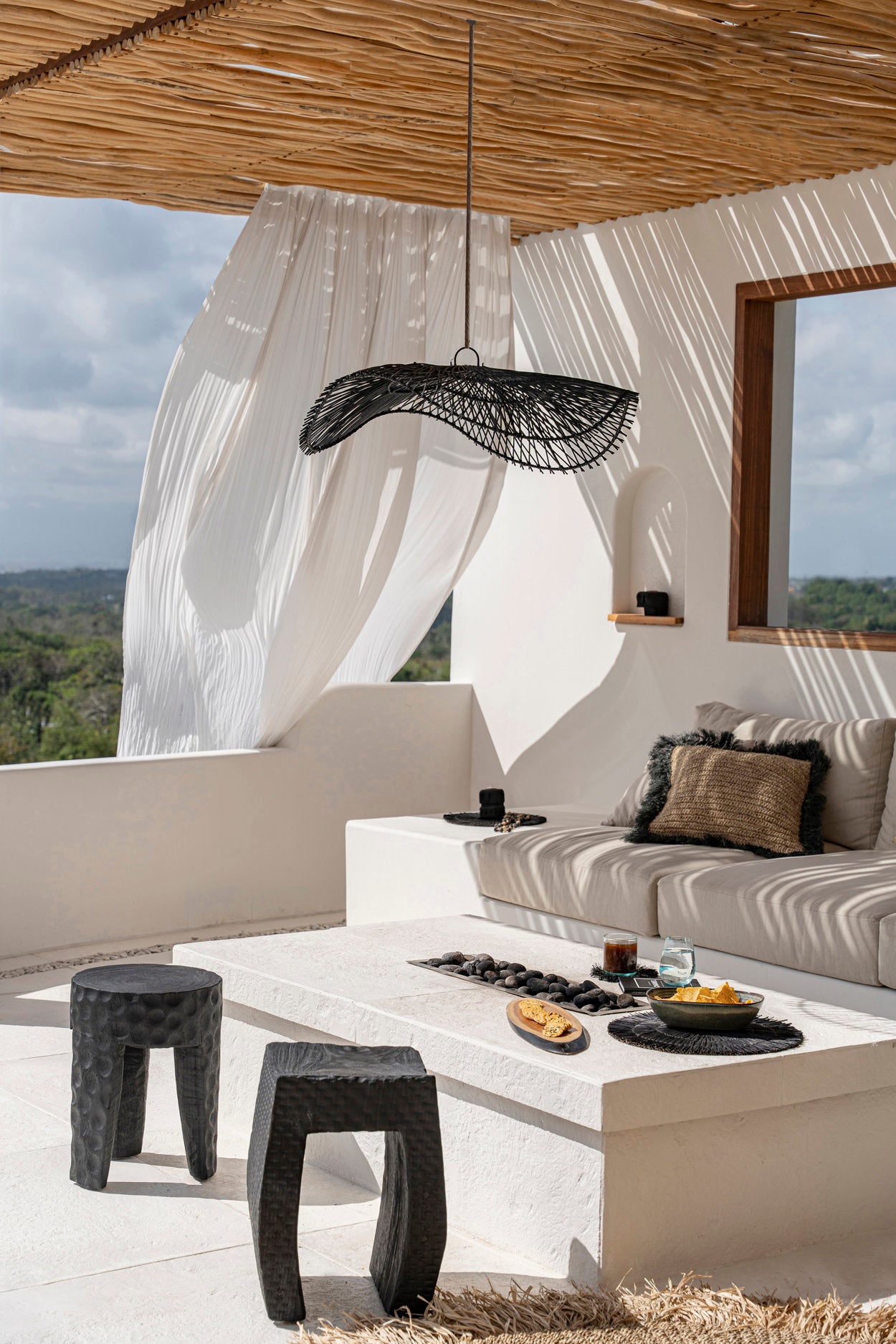 Black rattan pendant light inspired by hat shapes, perfect for warm lighting in dining areas