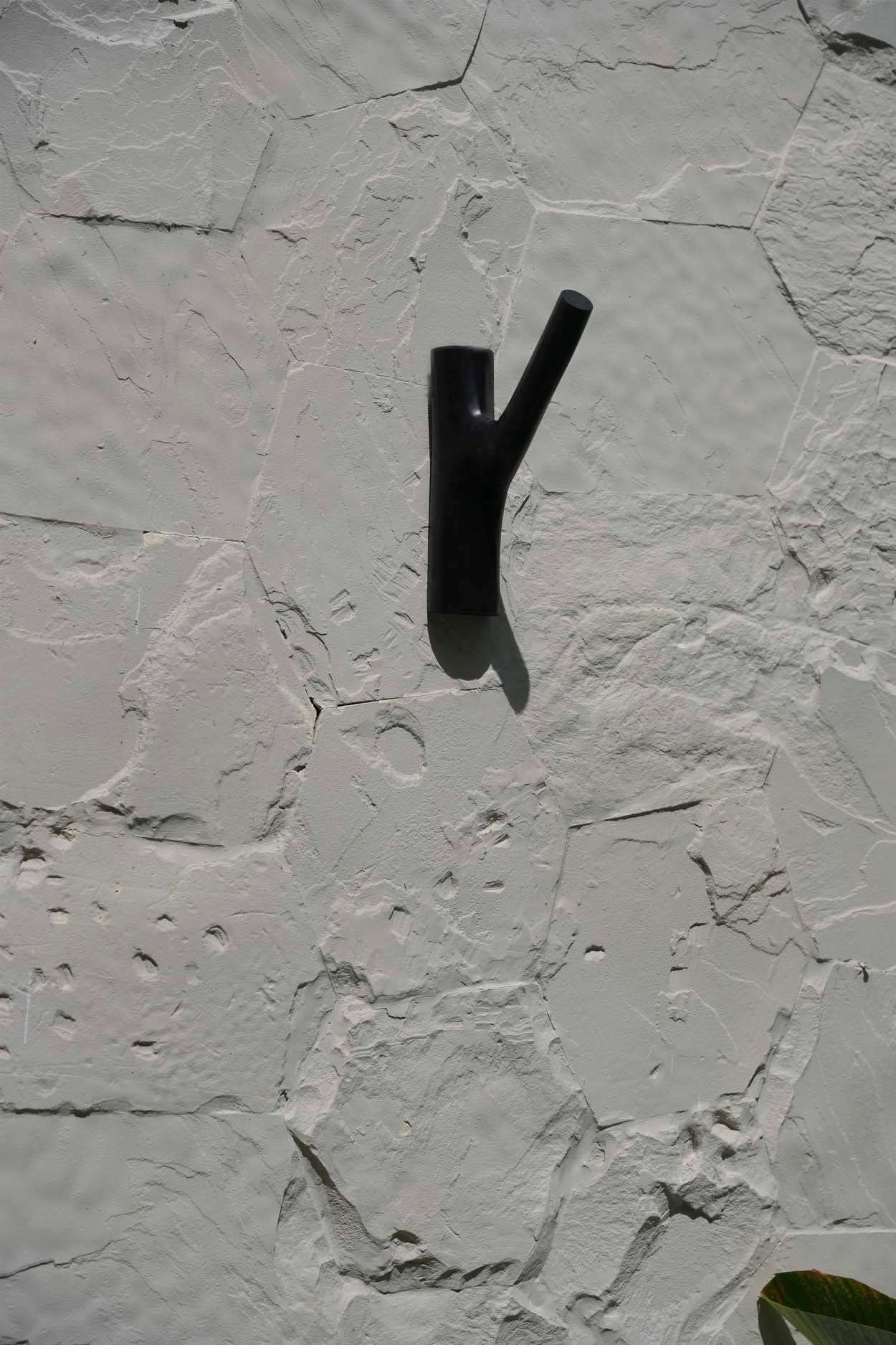 Handcrafted wooden coat hook with natural grain and sleek black tone