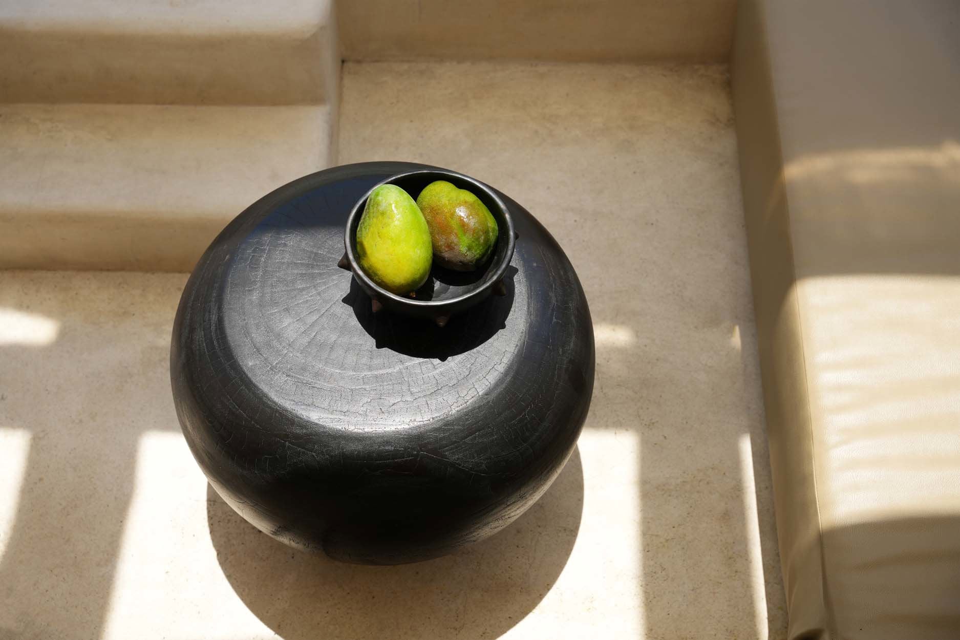 Black ceramic ethnic bowl, artisanal piece with striking spiky rim for modern dining.