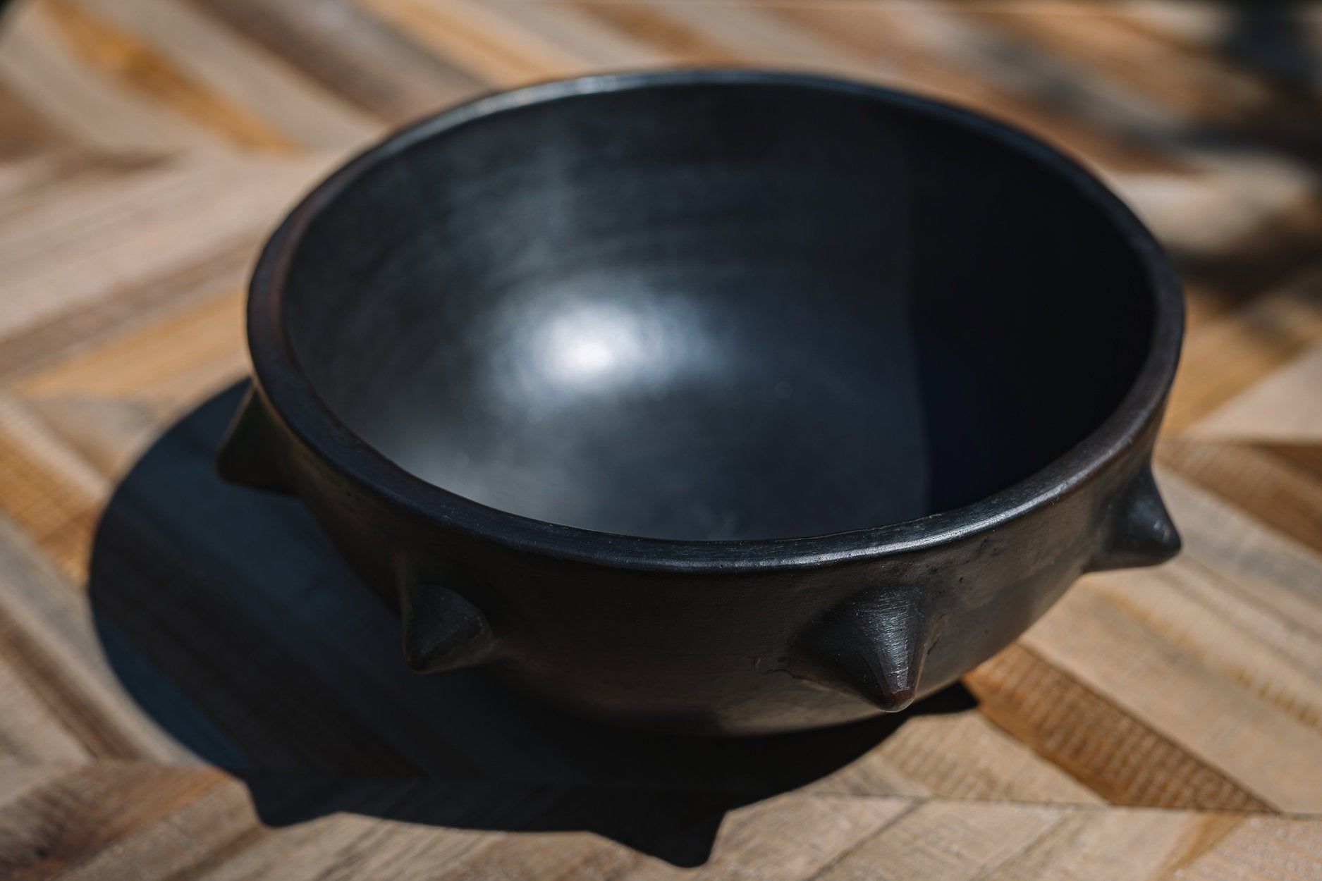 Rustic terracotta ethnic bowl in black, artisanal craftsmanship with bold textured finish.