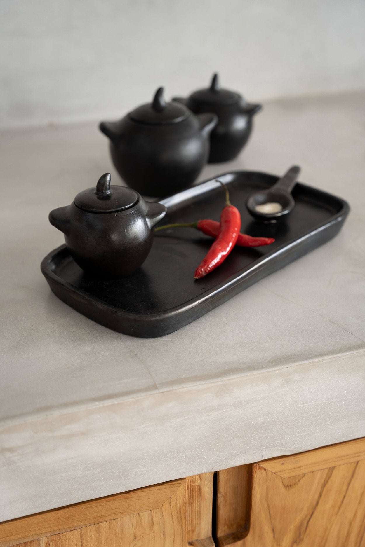 Unique small ceramic storage jar in black finish, handcrafted with artisanal detail.