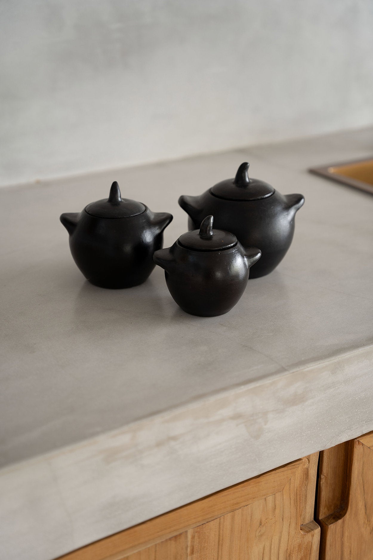 Small ceramic jar in black, perfect for storing spices and everyday ingredients.