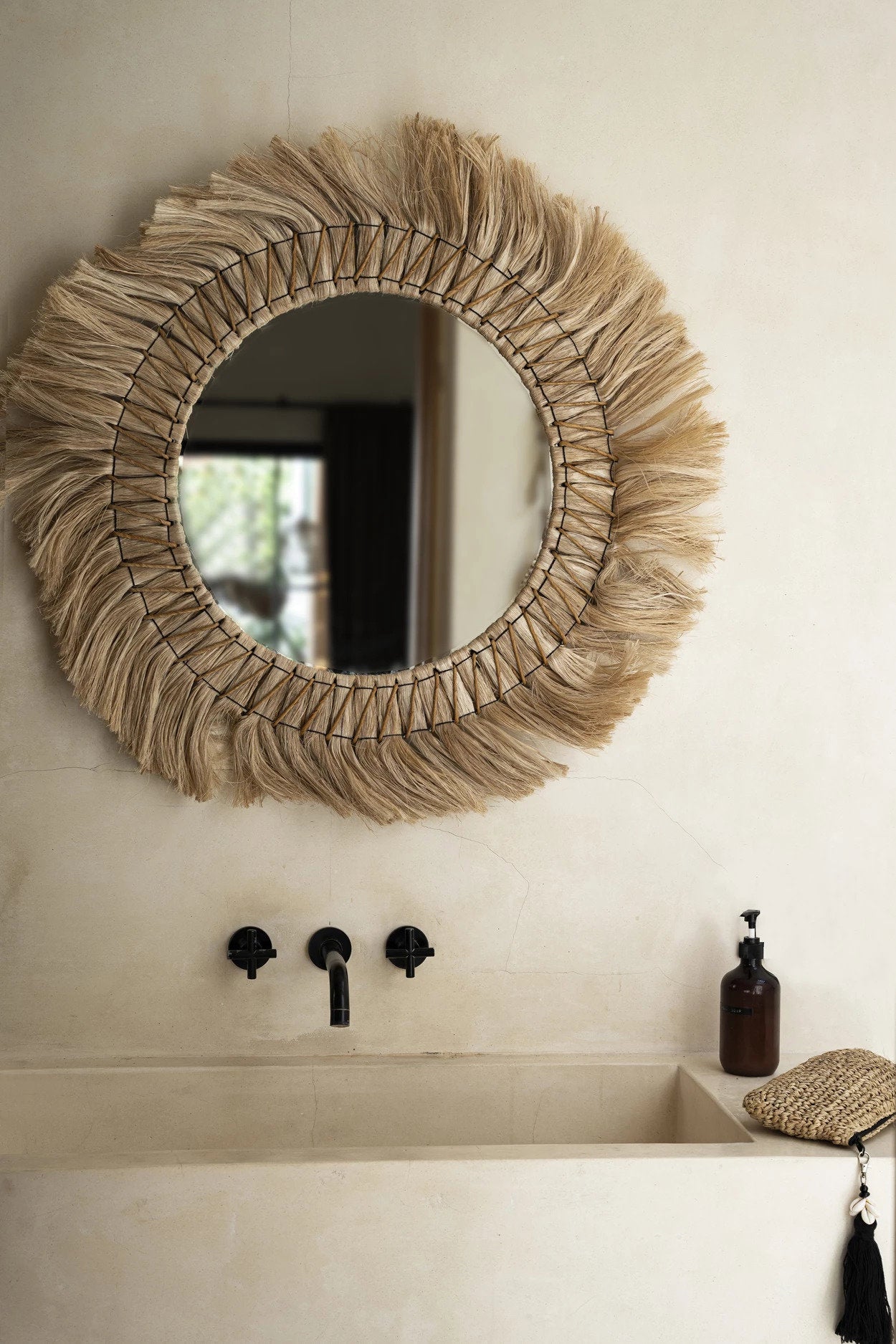 Round decorative wall mirror with natural grass frame, bringing breezy, organic charm to modern and boho spaces.