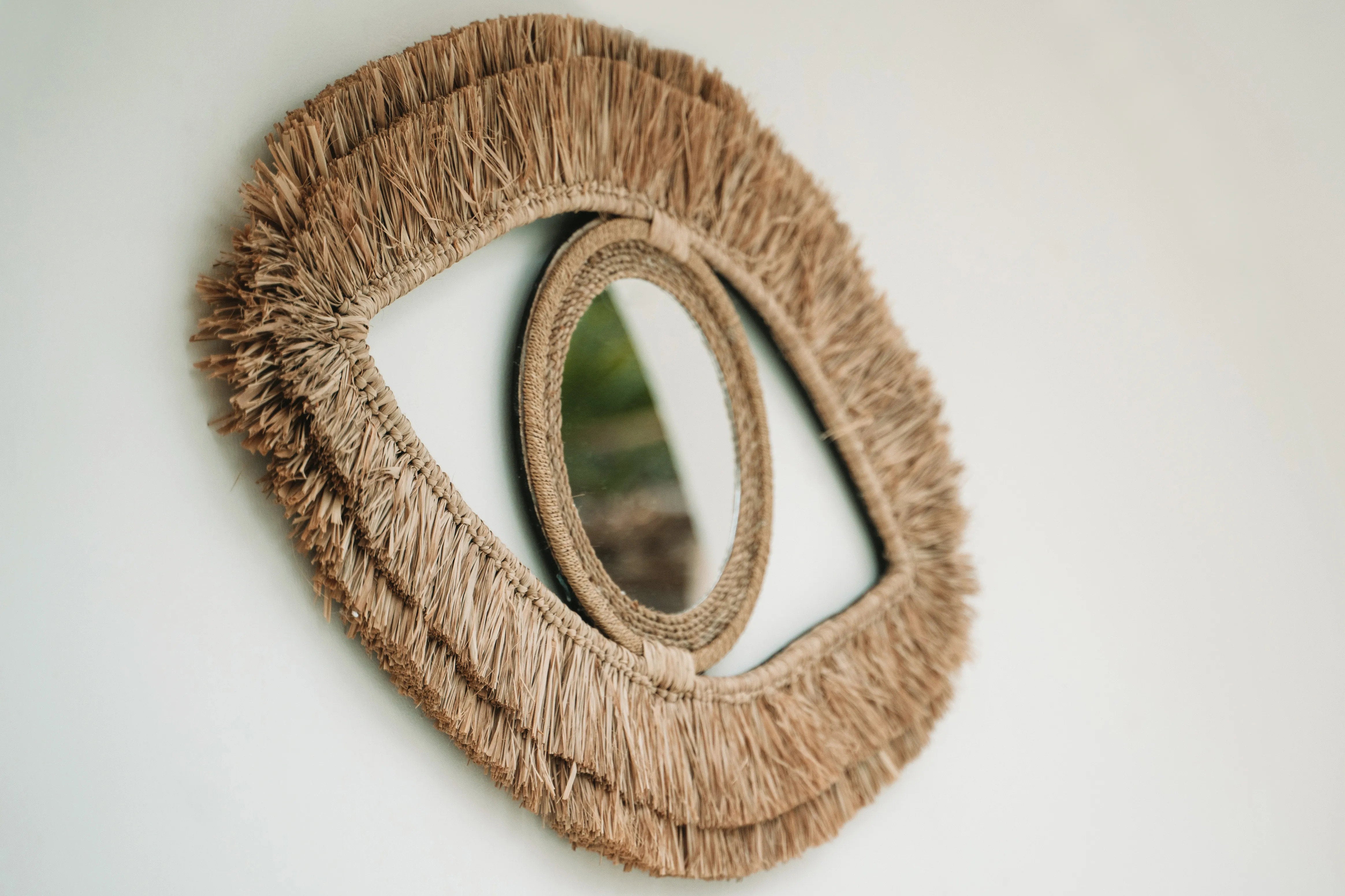 Decorative wall mirror crafted from sustainable raffia, perfect as a statement piece above a console or seating area.