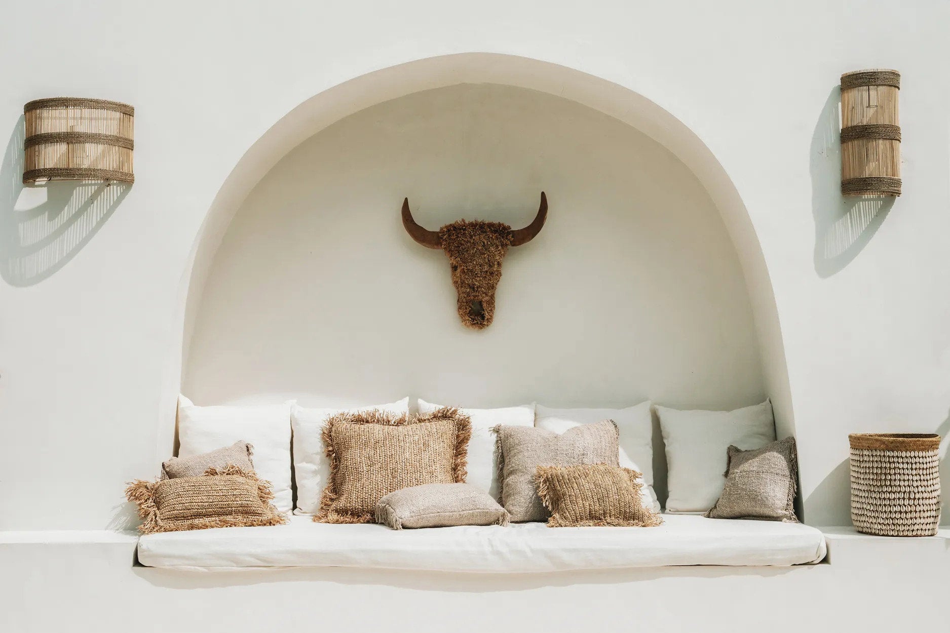 Natural rattan wall sconce styled in a bohemian living room, adding texture and warmth to the space.