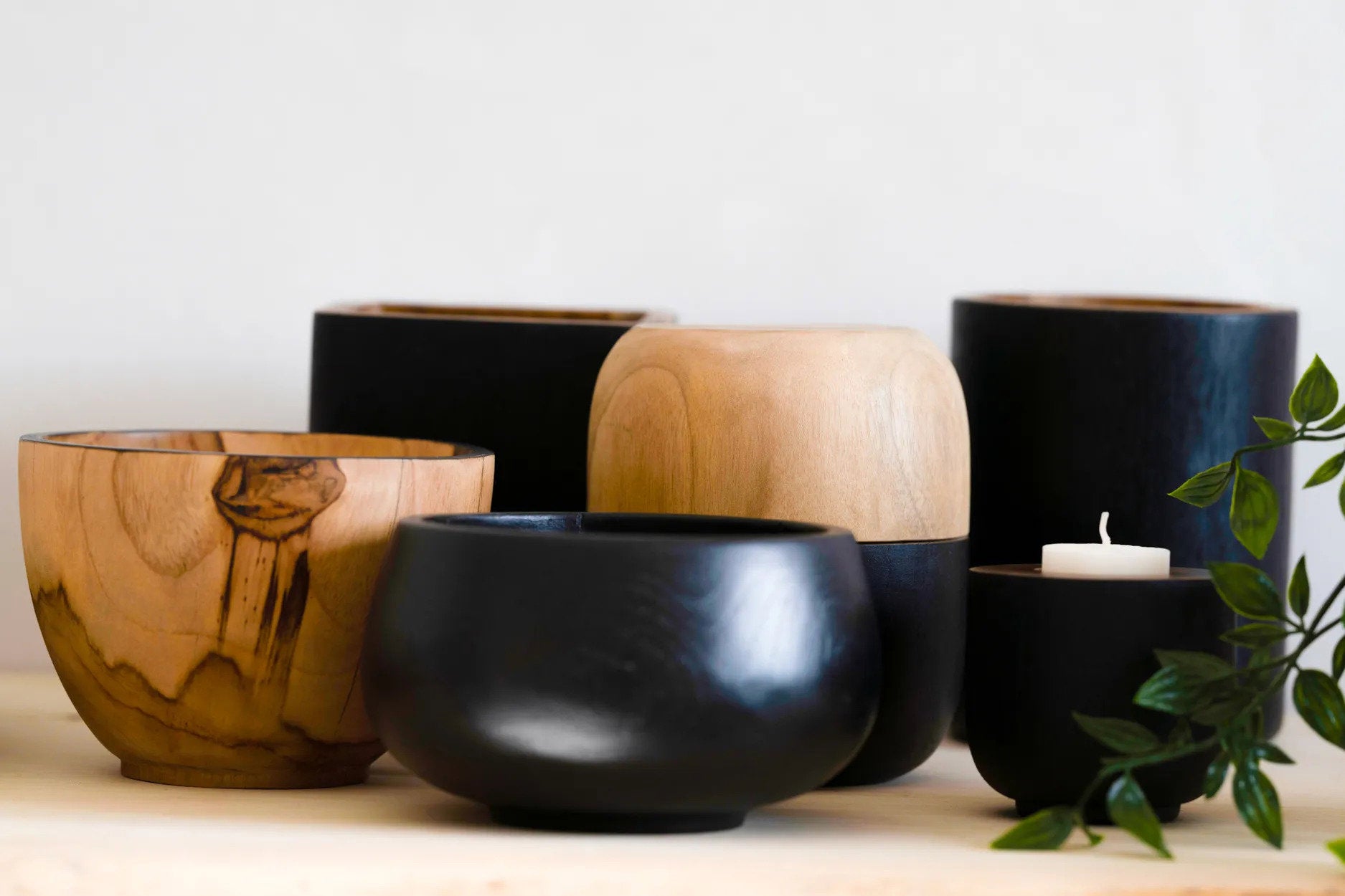 Minimalist round teak vase in matte black, ideal as a statement piece for living rooms or dining tables.