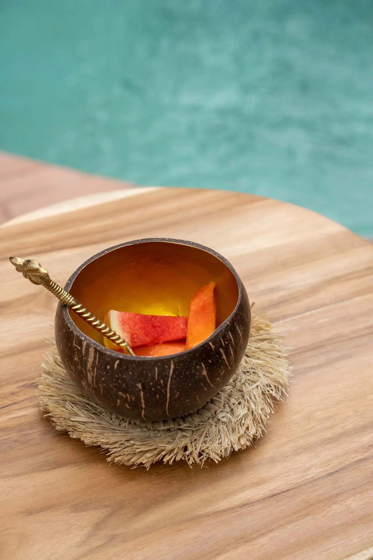 Natural raffia coaster with fringed edges, ideal for coffee cups, glasses, or decorative table settings.