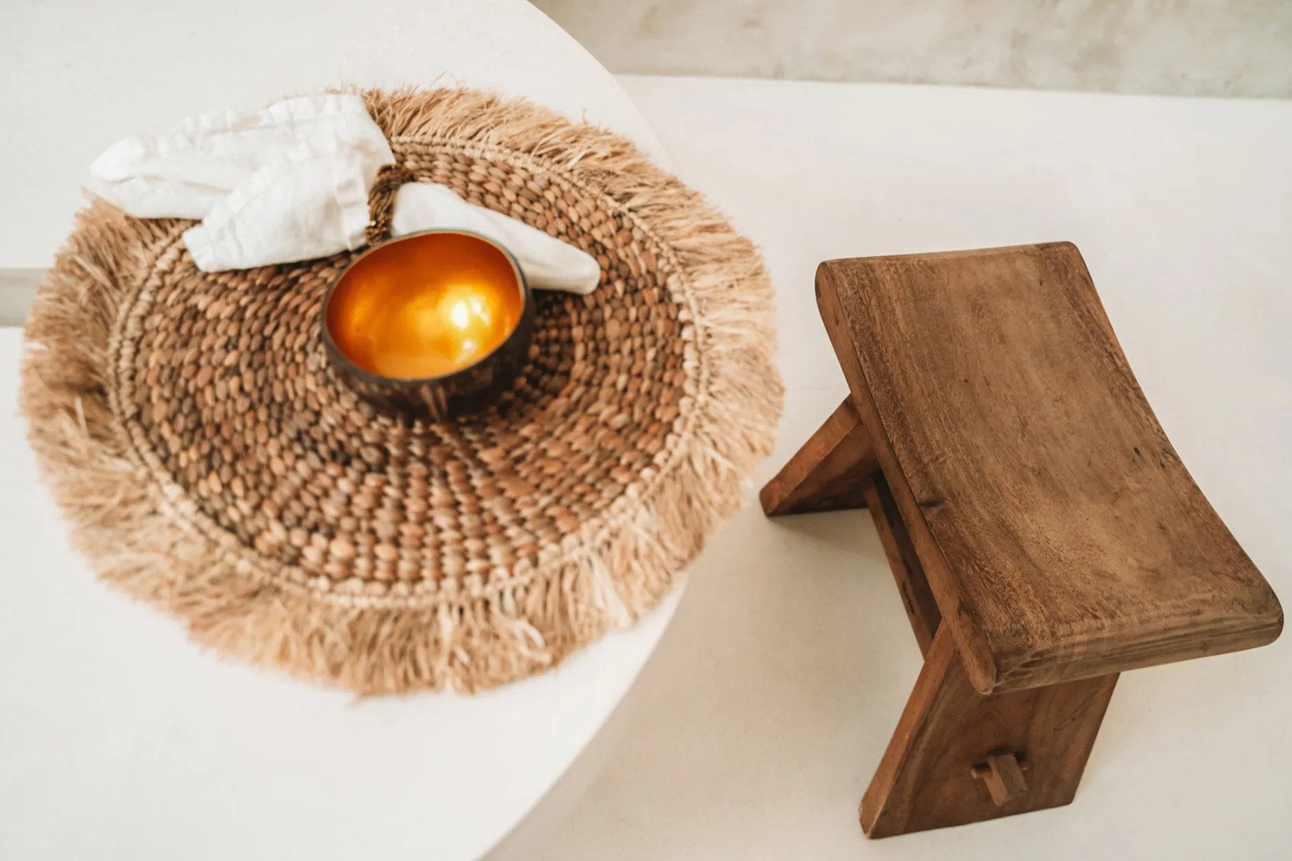 Rustic boho table accessory crafted from natural water hyacinth with delicate raffia edging.