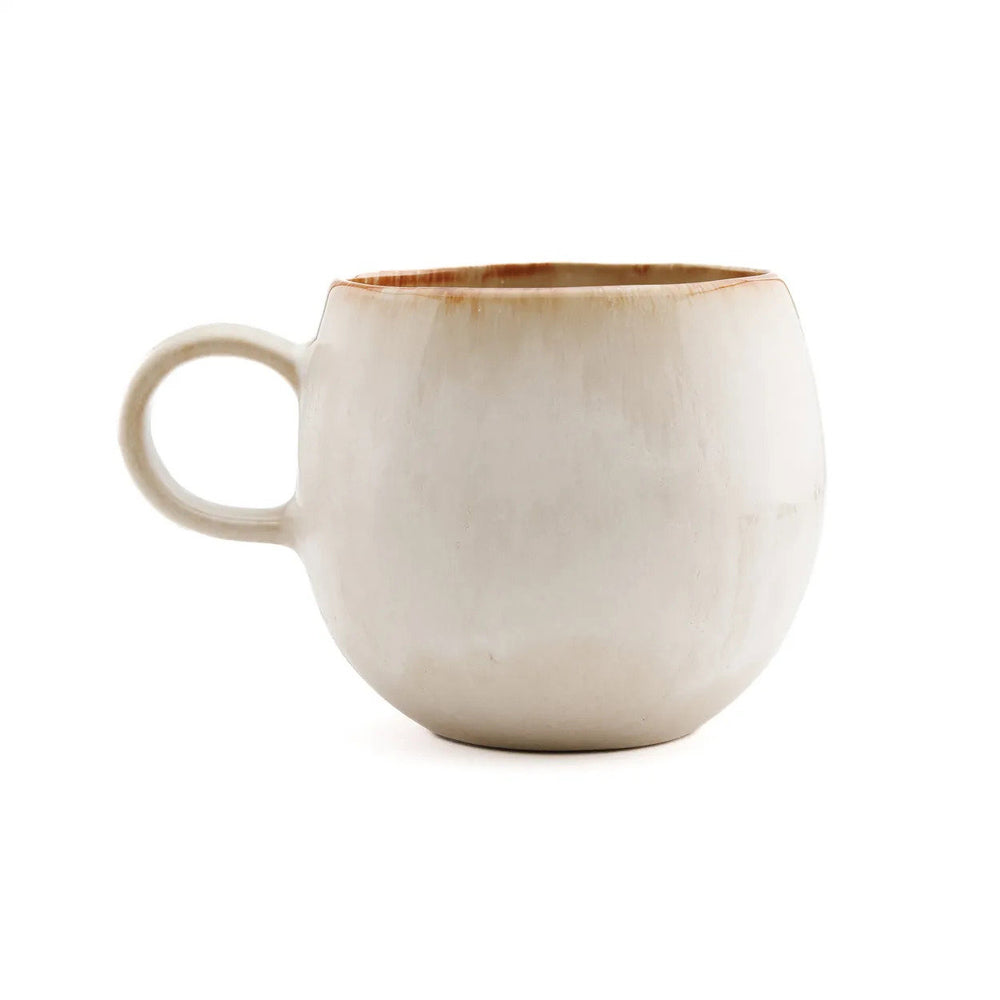 The medium ceramic mug stands in soft light, its white glaze resting gently over grounded stoneware