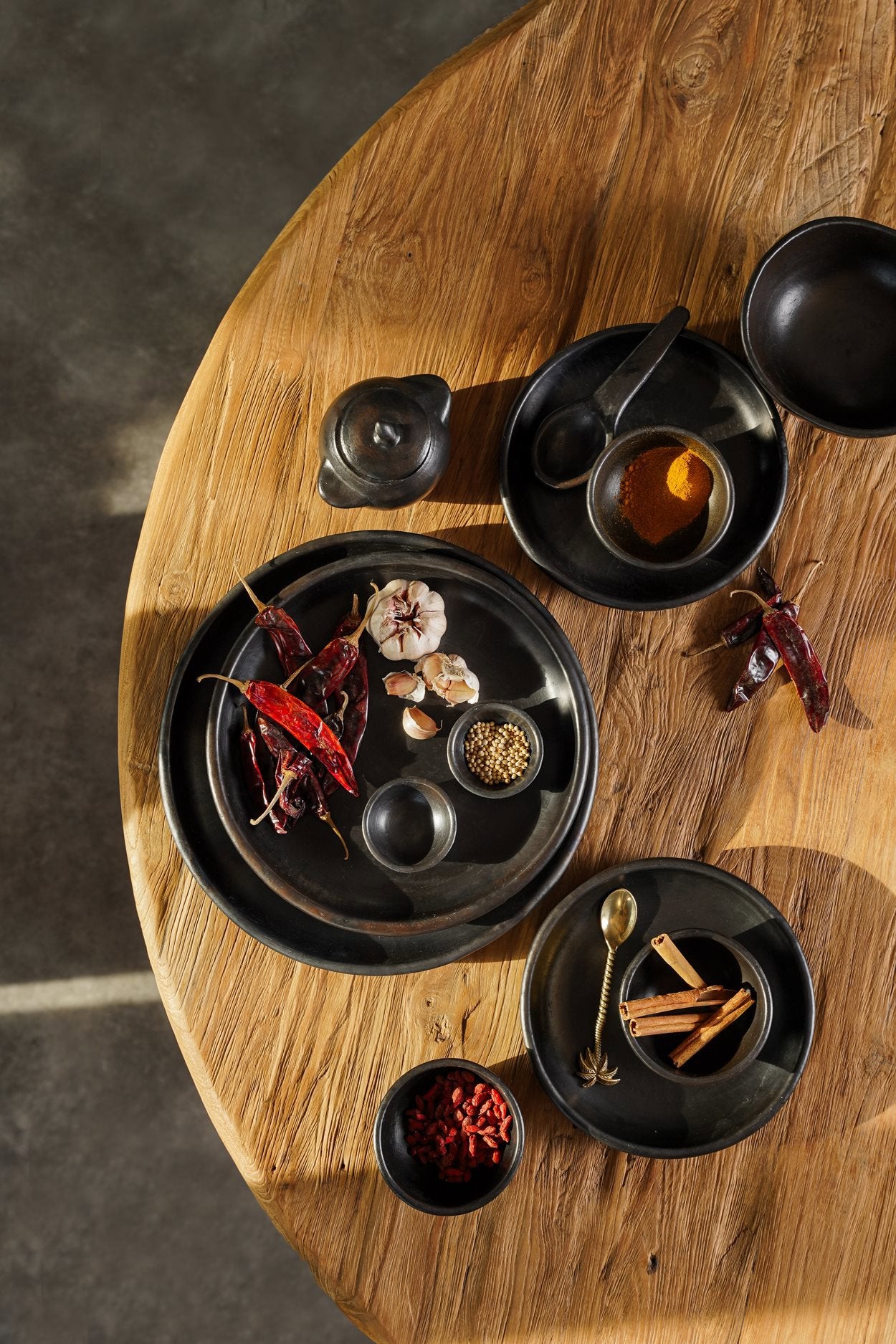 Medium handmade black plate with deep form, perfect for pasta, salads, or shared dishes.