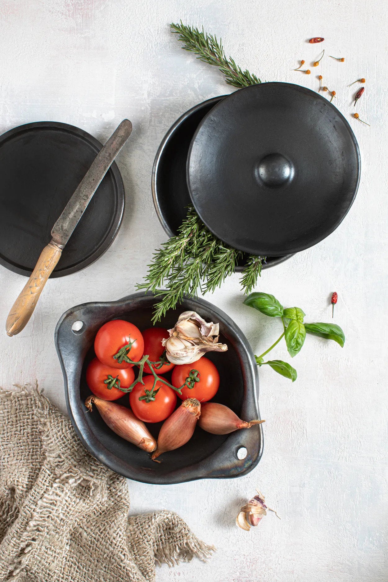 Black ceramic pot with rustic finish, oven safe and microwave safe for versatile use.