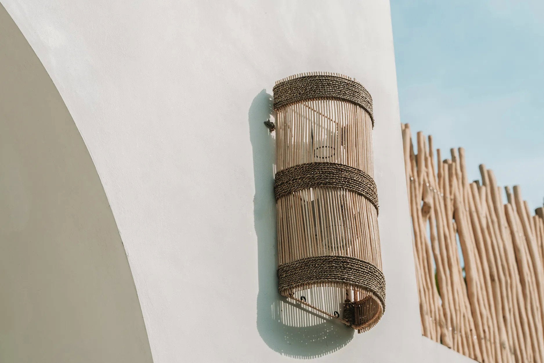 Medium-sized rattan wall light placed near a doorway, offering functional illumination with earthy, organic style.