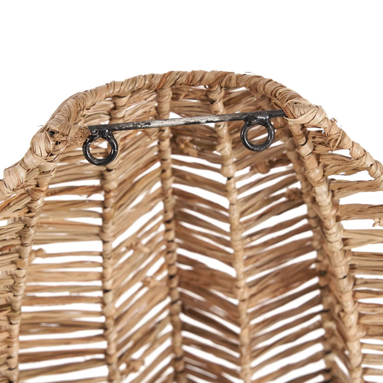 Natural raffia wall light placed in a cozy entryway, creating an inviting atmosphere with its soft, ambient lighting.