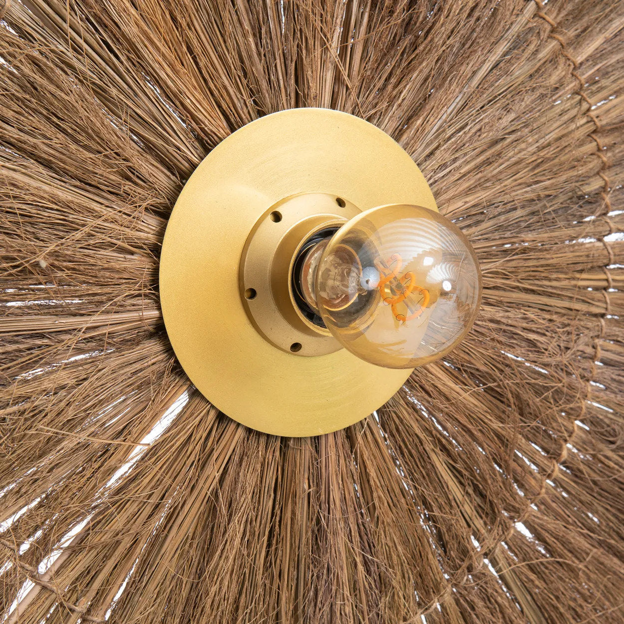 Close-up of The Chi-Chi’s handmade design, showcasing the contrast between natural fibers and a brass-toned iron frame.