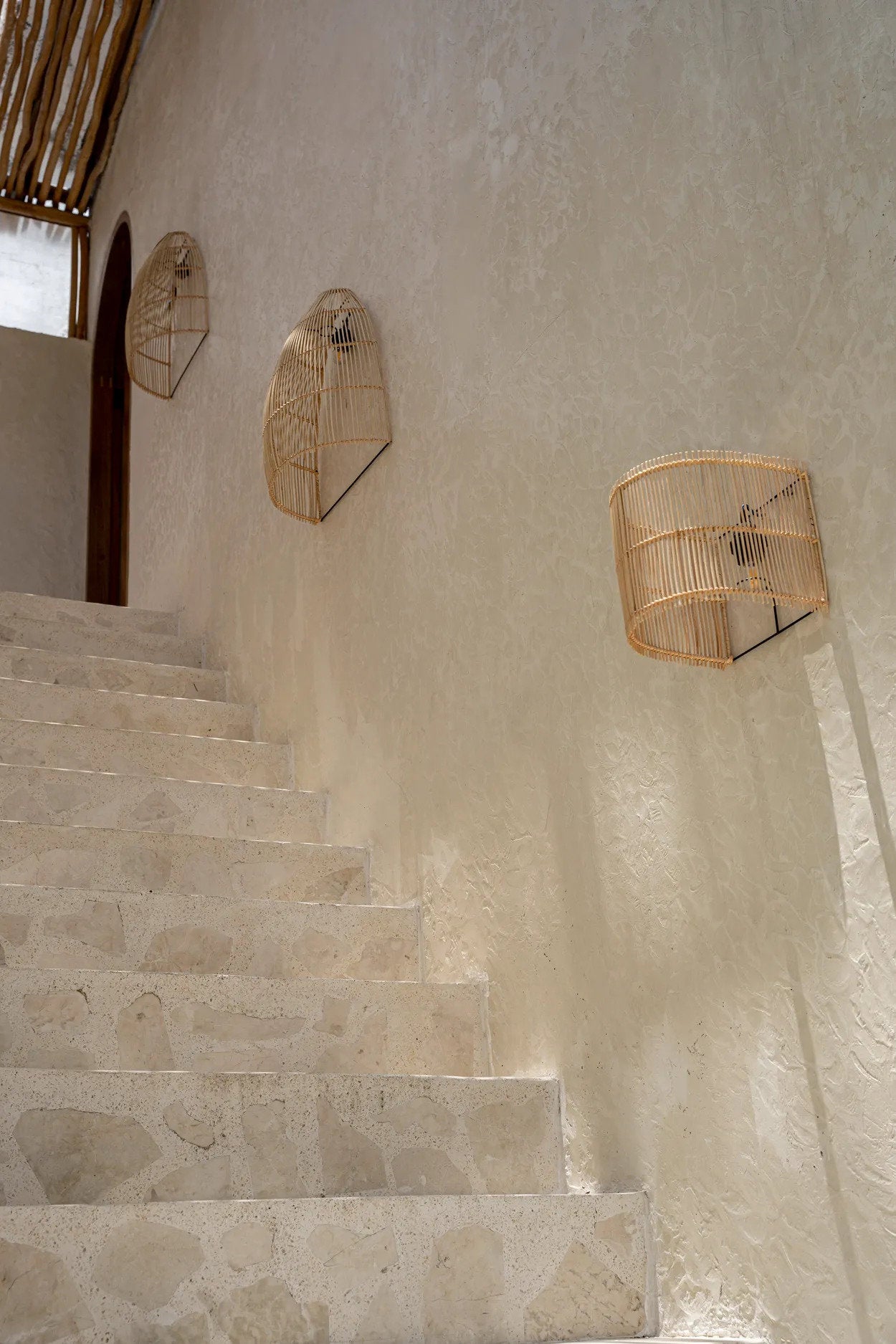 Outdoor seating area featuring The Gigi Wall Applique, adding a relaxed coastal feel with its natural materials and soft glow.