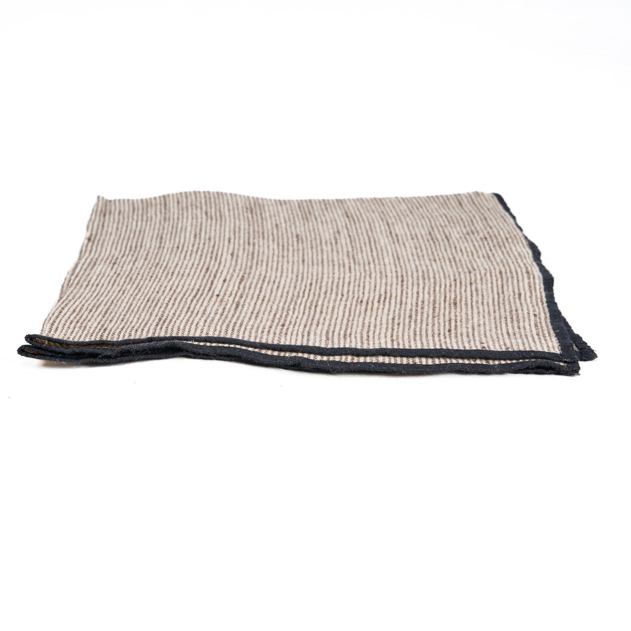 Close-up of striped linen napkin in black and natural tones, showcasing soft weave and sustainable design.