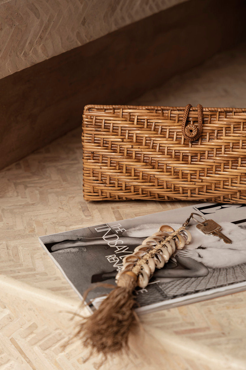 Neutral-toned natural raffia clutch, small yet practical for day-to-night wear.