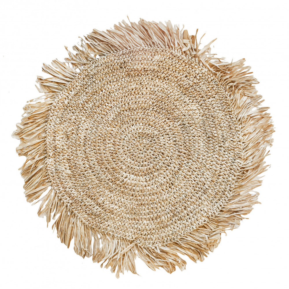 Woven round raffia placemat featuring a spiral weave pattern and raw frayed edges, organic dining accessory.