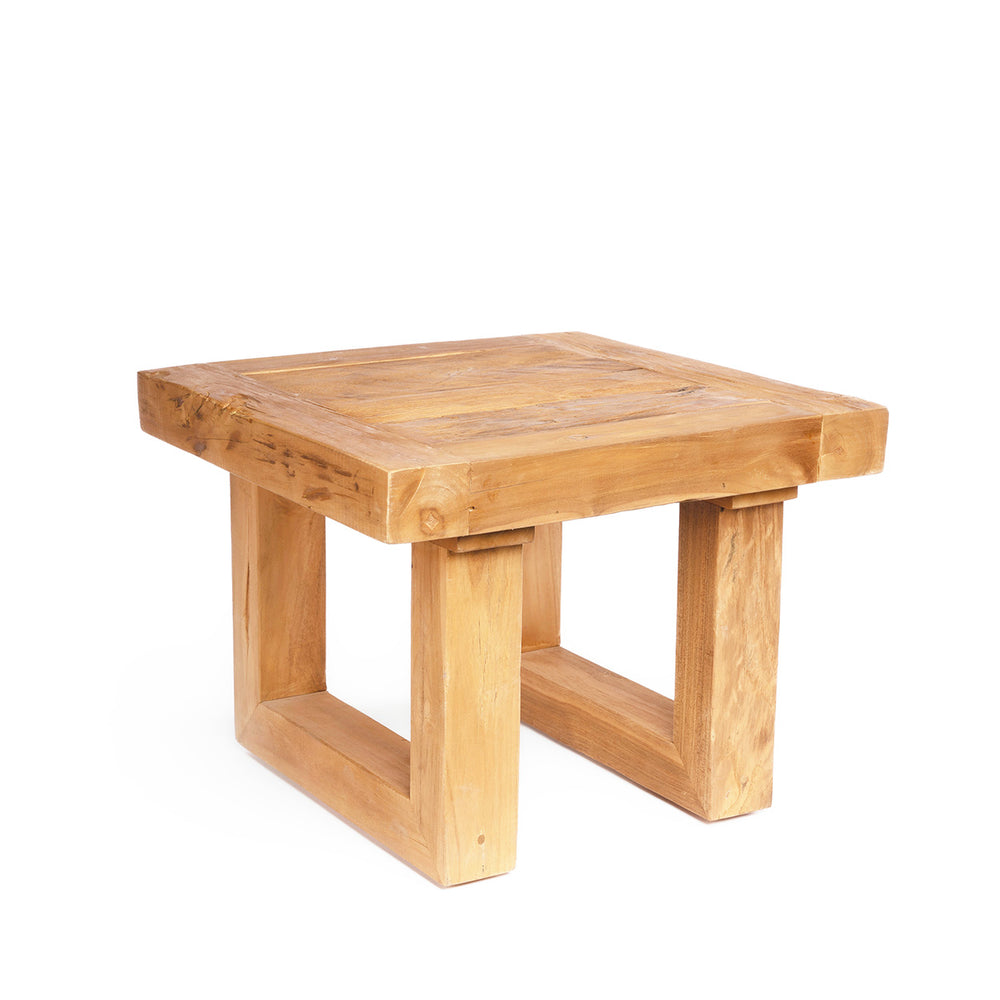 An u-shaped leg table with a sun-baked finish, hand-carved from reclaimed teak wood.