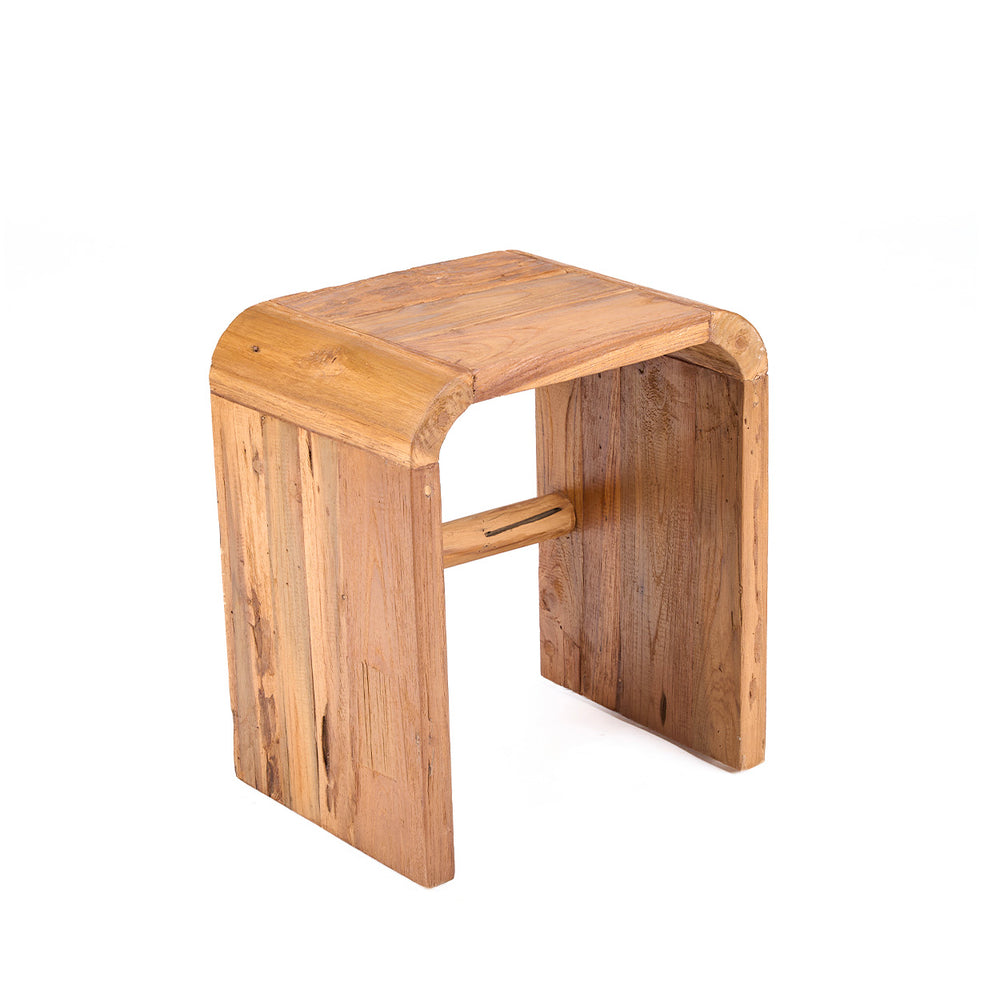 A teak side table with soft curved edges and warm natural grain, crafted from solid wood that glows gently in natural light.