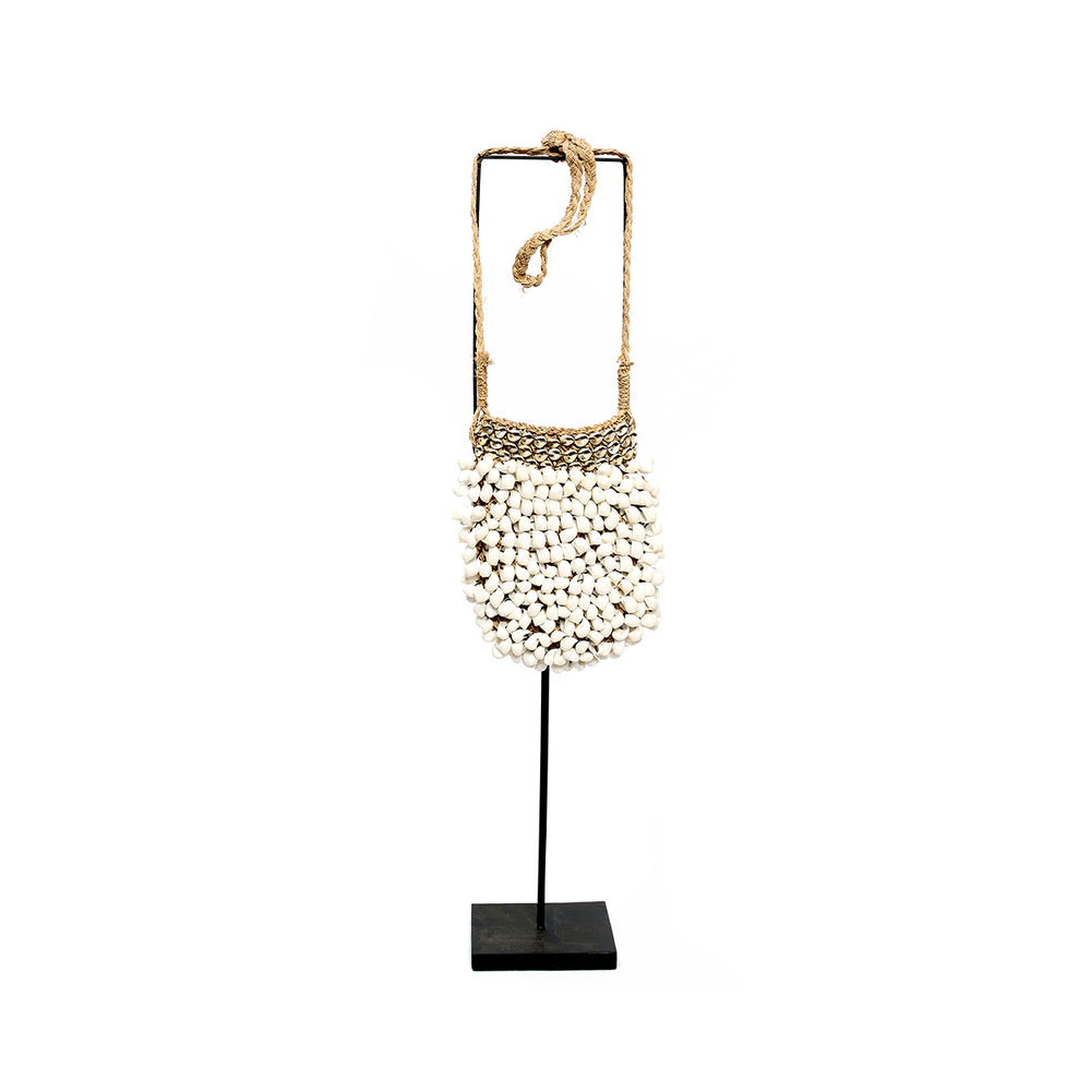 A shell decor on stand in a natural white hue, completed with a pedestal display.
