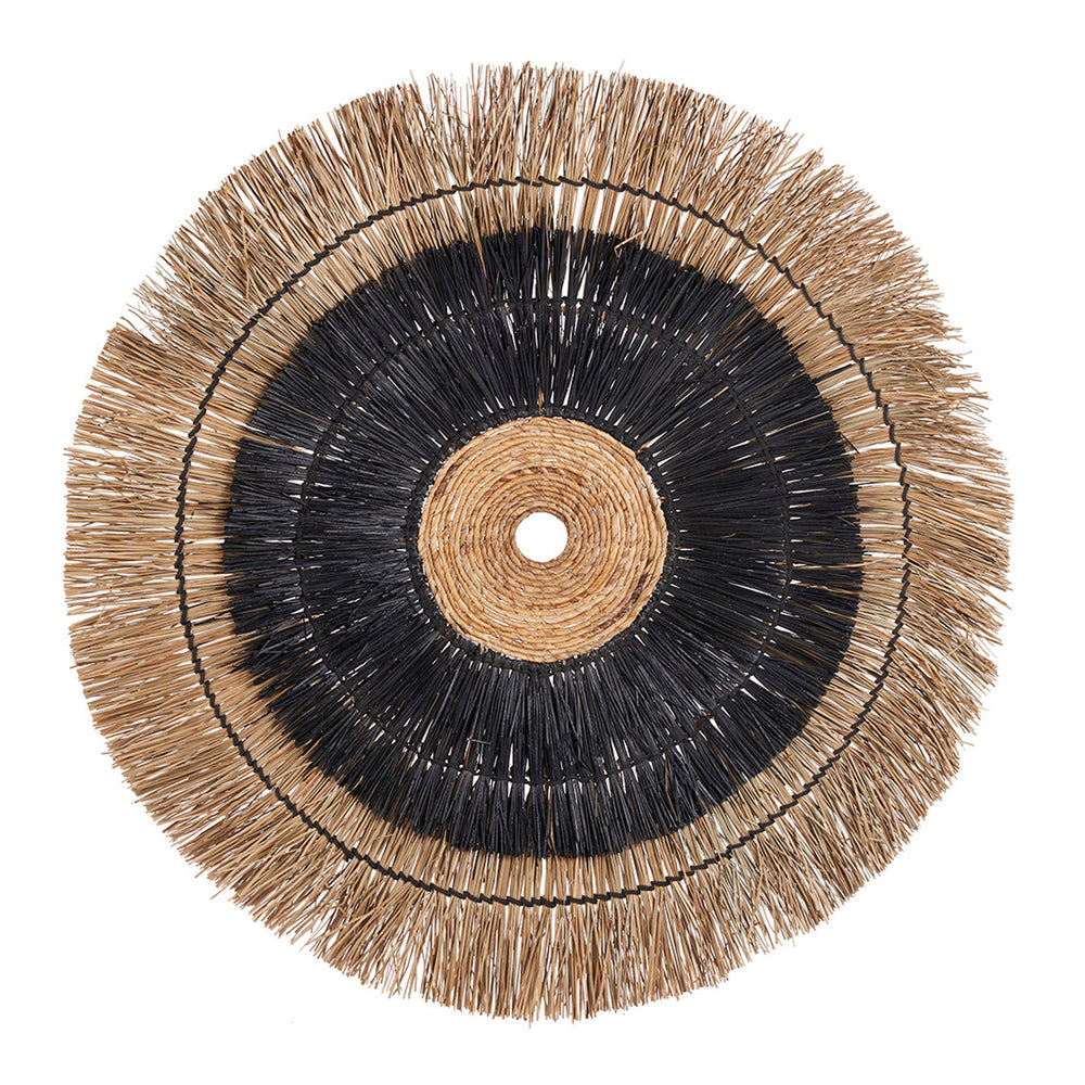 A natural fiber wall accent featuring a striking circular composition with layered textures, made from banana leaf and mendong grass in natural and black tones.