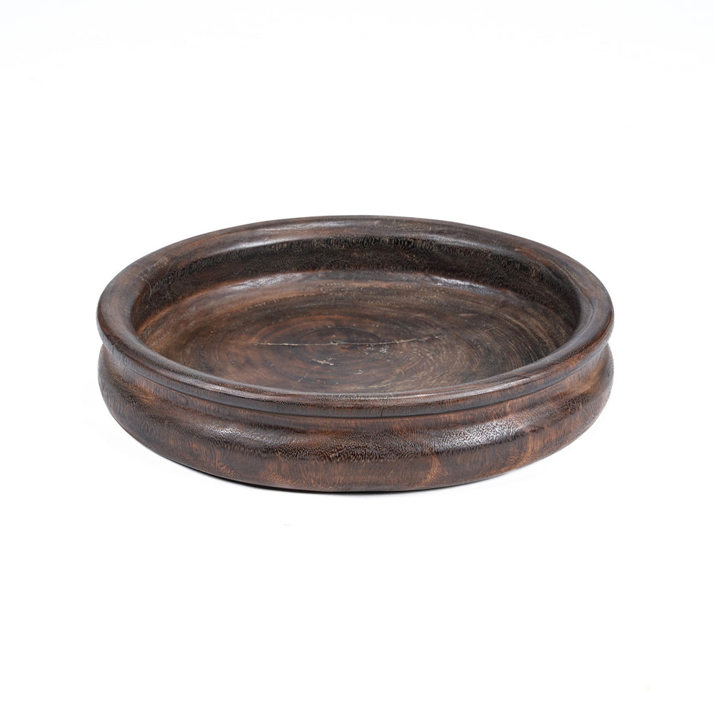 A dark walnut wooden bowl made from raw mango wood, showcasing its natural hue and delicate grain.
