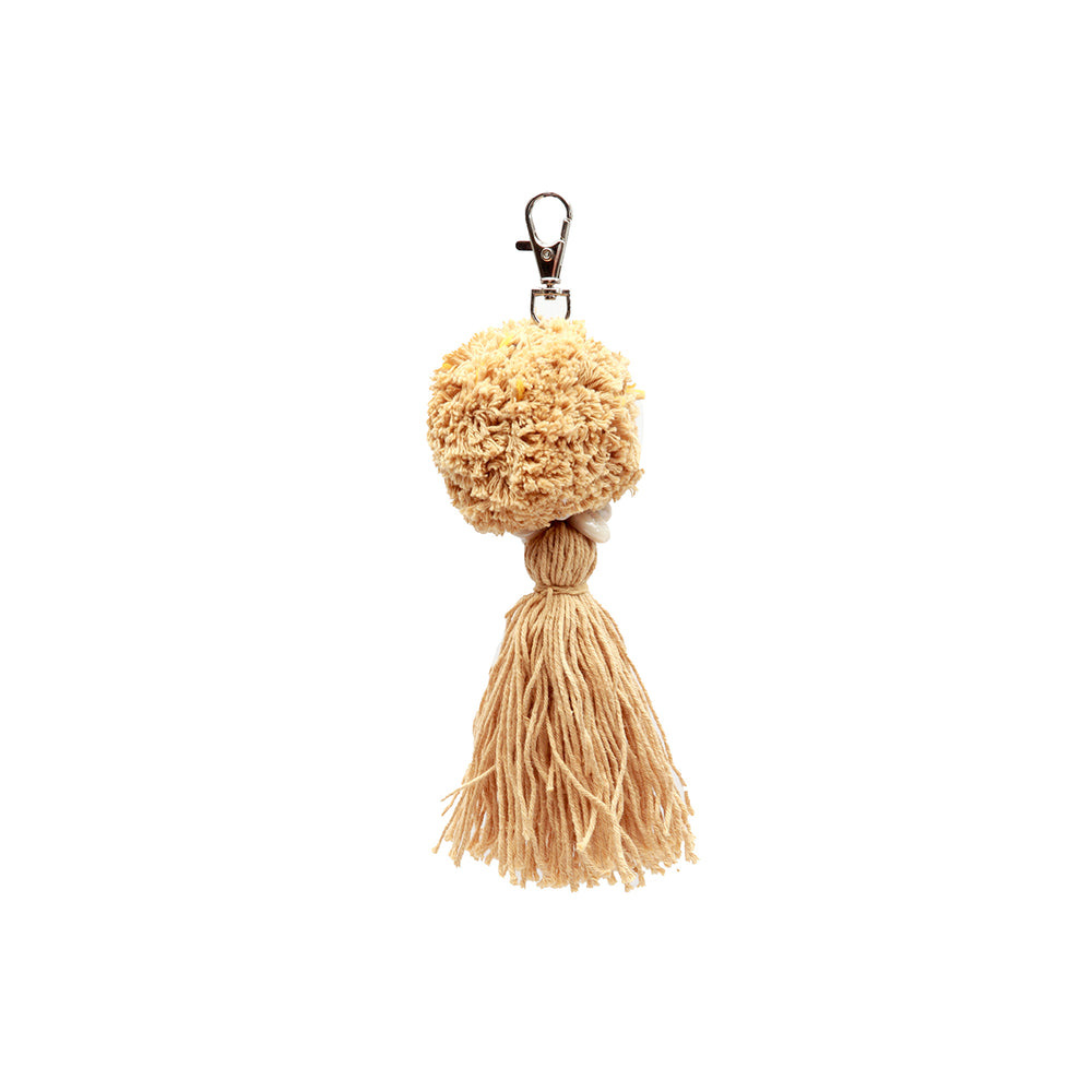 A pompom keychain in mocca tone, made from cotton with a fringe.