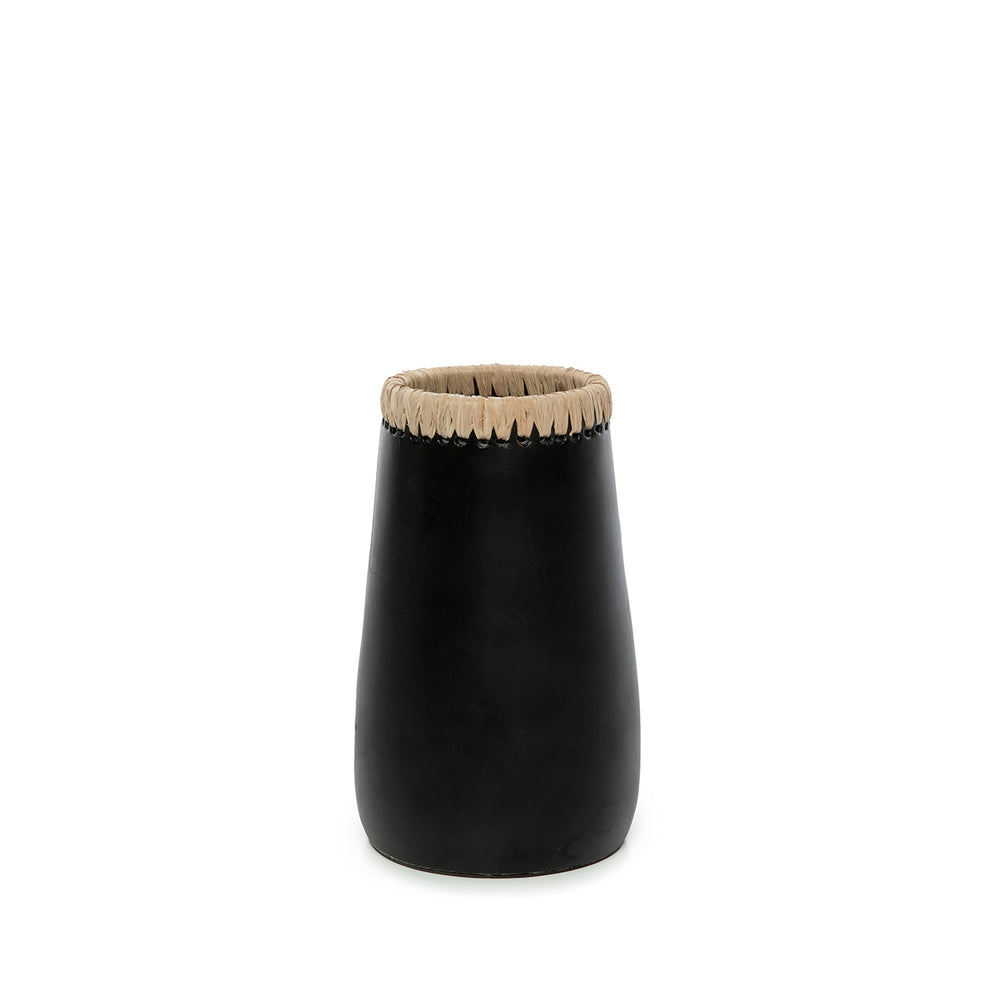 A black terracotta vase for table with fibrous raffia along the upper rim and sleek body.