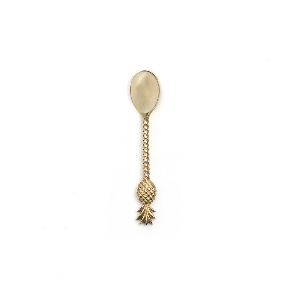 A golden brass tea spoon in a playful, twisted handle, crowned with a pineapple accent.