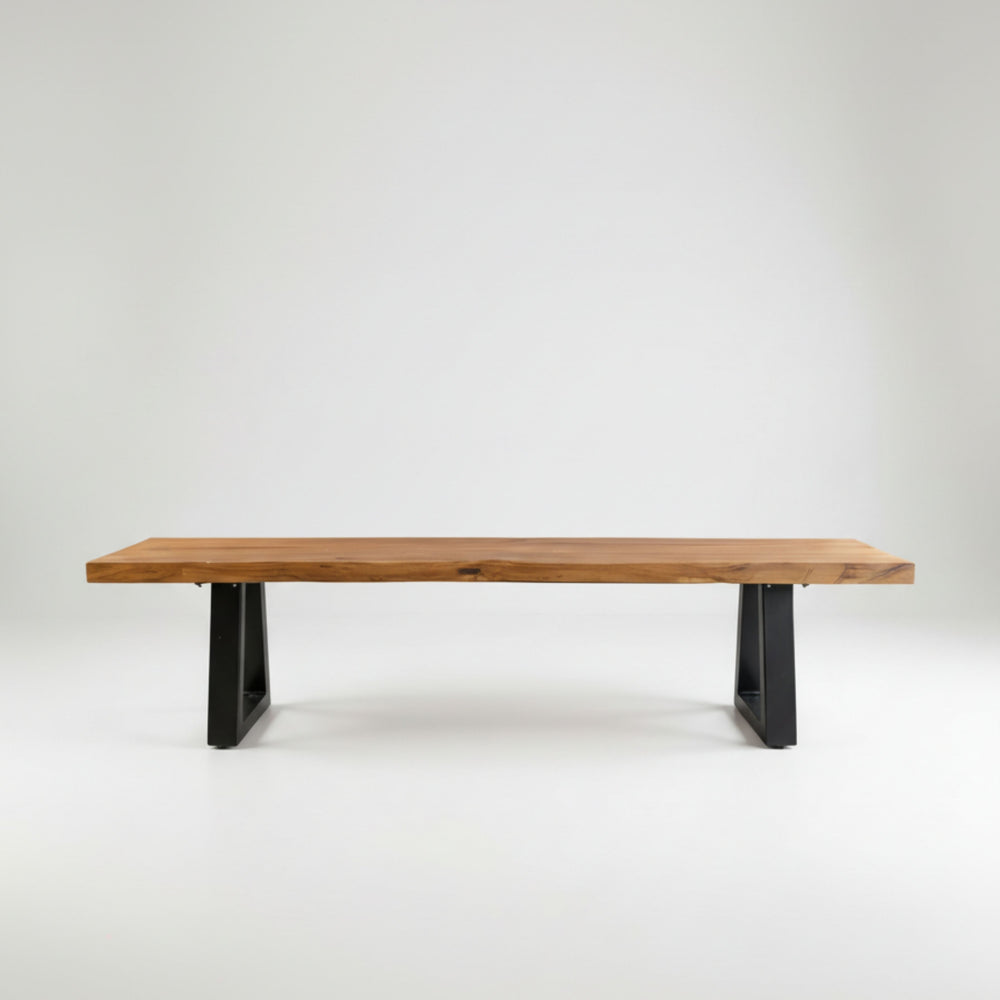 A minimalist modern rustic iron leg bench handcrafted from a long, natural-finish reclaimed teak wood slab resting on two geometric black iron legs.