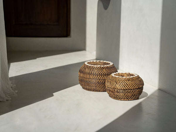 Round rattan baskets casting shadows on light floor.