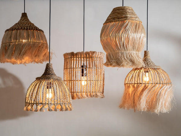 Five pendant lights in varied sizes and styles, casting a warm glow from their bulbs.