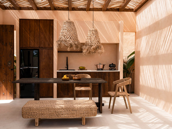 Rustic kitchen with wooden beams, woven lights, and a cozy dining area.