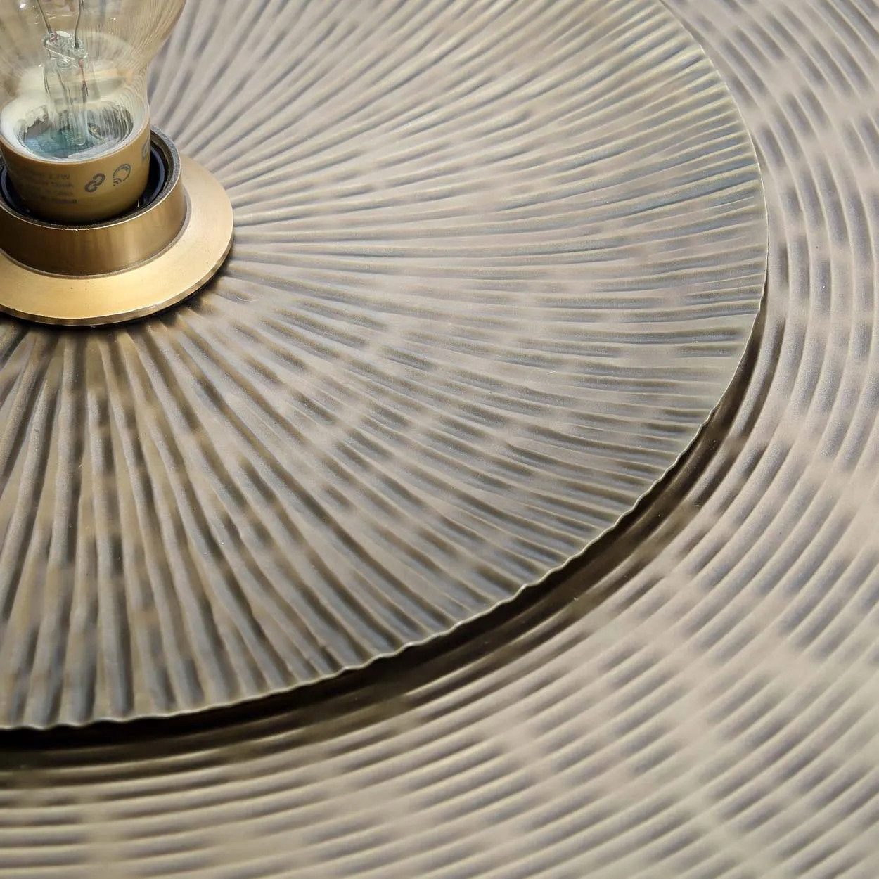 Close-up of handcrafted brass discs with natural variations in color and texture, highlighting artisanal craftsmanship.
