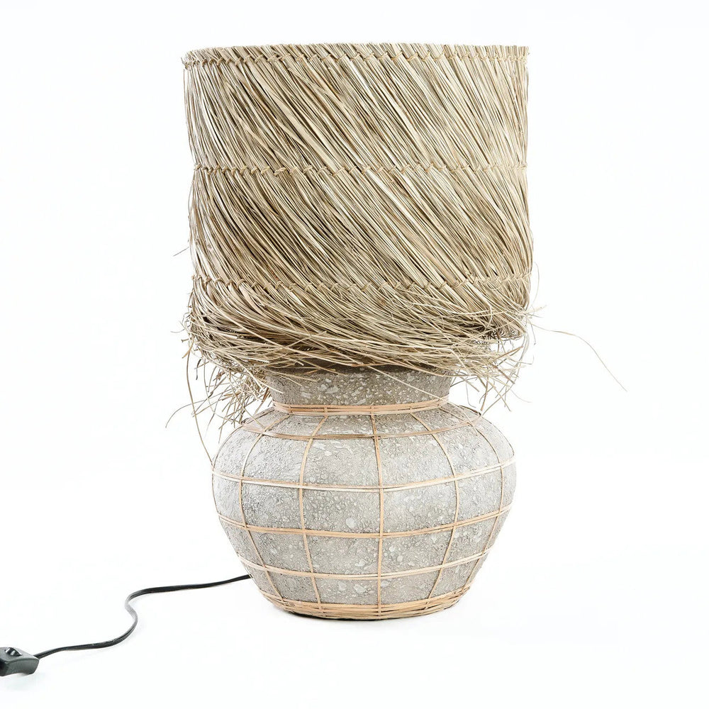 A natural concrete table lamp for indoor settings, made of terracotta and raw grass.