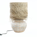 A natural concrete table lamp for indoor settings, made of terracotta and raw grass.