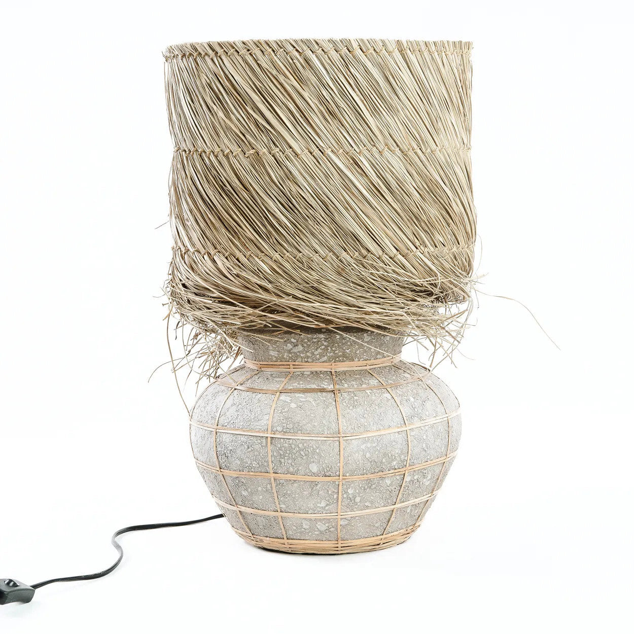 A natural concrete table lamp for indoor settings, made of terracotta and raw grass.