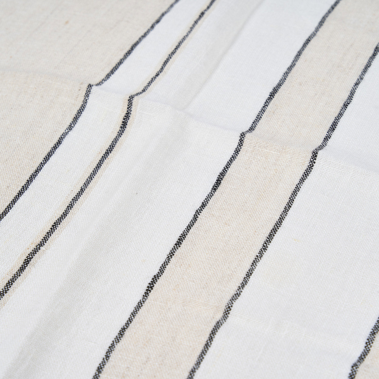Linen table napkin with natural color variation, highlighting sustainable, high-quality craftsmanship.