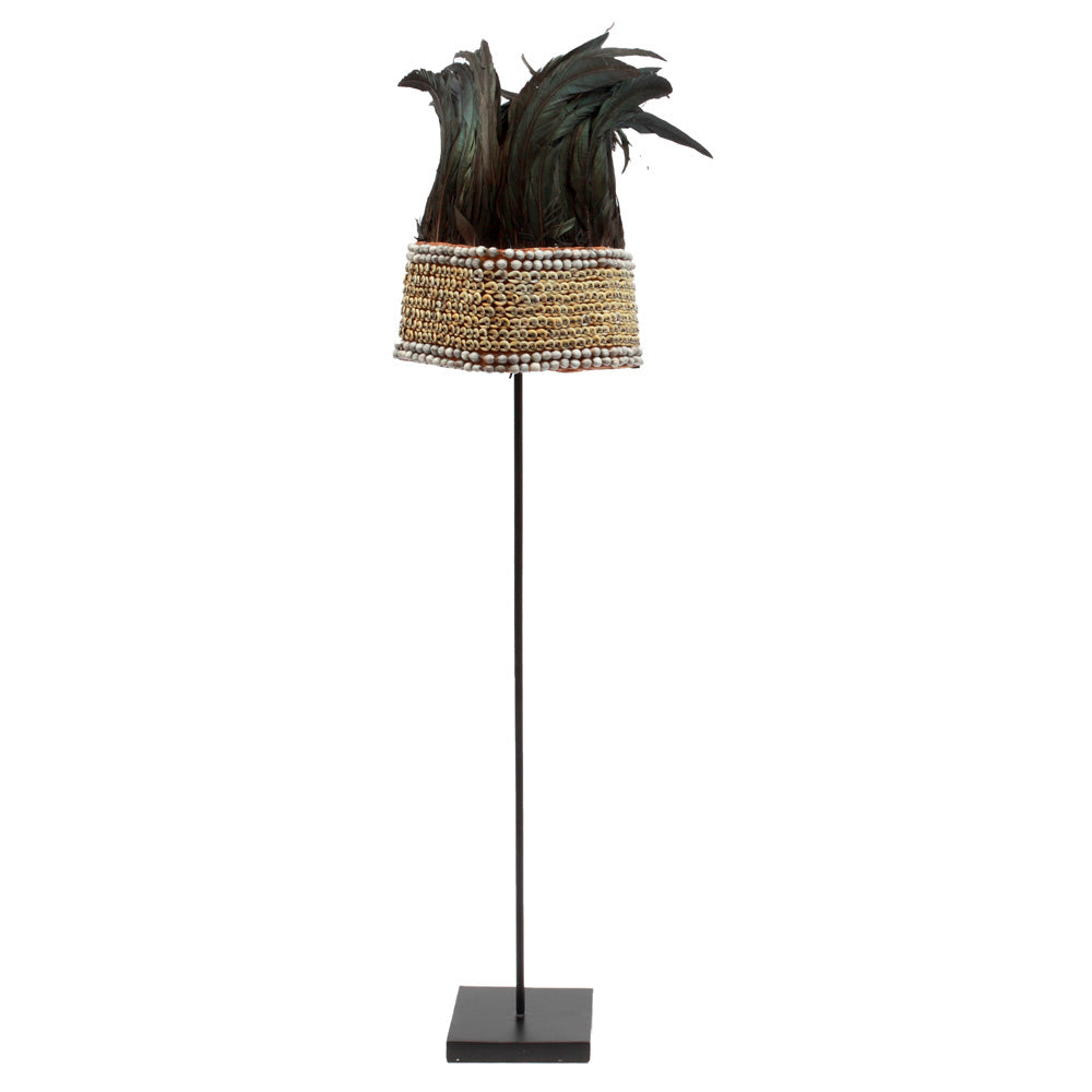 A feather hat on stand for home decor, featuring tribal presence with deep black plumage.